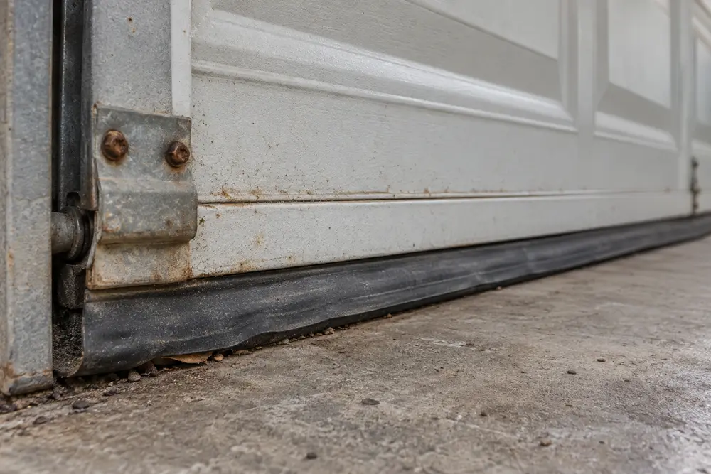 Aged garage door bottom seal and worn hinge hardware during a condition inspection