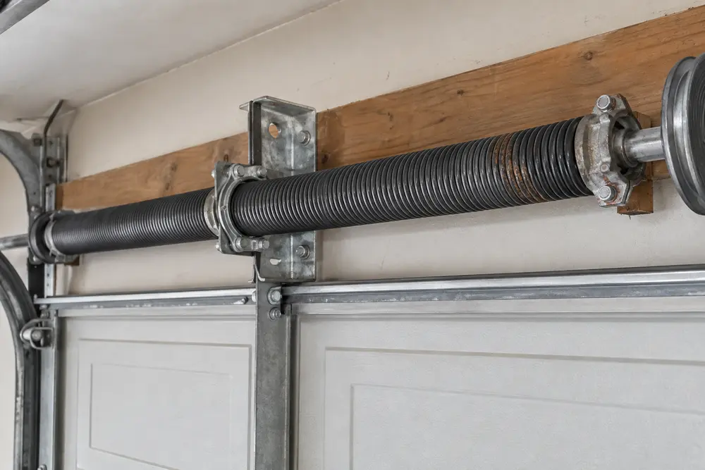 Close view of surface wear and corrosion on a garage door torsion spring